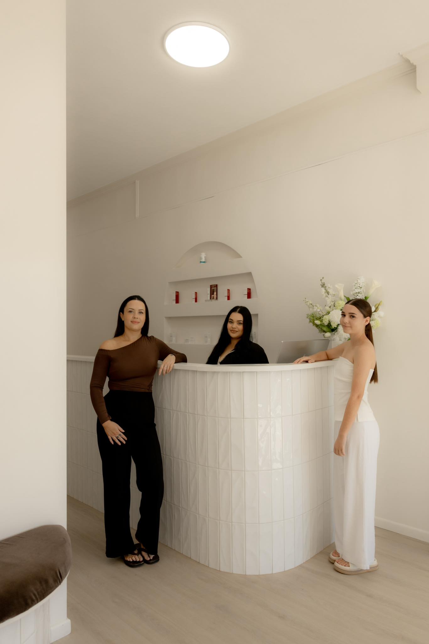 The studio reception, with a curved fluted tile desk and an arched product niche